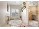 Bright bathroom with a fireplace, soaking tub, and tiled shower at 633 W Aster Ct, Chandler, AZ 85248