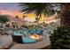 Outdoor fire pit and lounge area overlooking the lake, surrounded by lush greenery and palm trees at 633 W Aster Ct, Chandler, AZ 85248