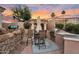 This outdoor kitchen is perfect for entertaining with a built-in grill, bar seating, and lush landscaping at 633 W Aster Ct, Chandler, AZ 85248