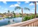 Scenic water view from a balcony, showcasing beautiful lake homes and palm trees under a blue sky at 633 W Aster Ct, Chandler, AZ 85248