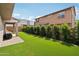 The backyard showcases an expansive artificial lawn, neatly trimmed hedges, and a covered patio ideal for outdoor dining at 670 S Beebe St, Gilbert, AZ 85296