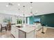Open-concept kitchen featuring white cabinets, an island with seating, and a view to the living area at 670 S Beebe St, Gilbert, AZ 85296