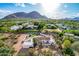 Aerial view of a luxury home featuring a sparkling pool, lush landscaping, and red tile roof with mountain backdrop at 6701 E San Miguel Ave, Paradise Valley, AZ 85253