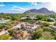 Beautiful aerial view of an estate featuring a circular driveway, stunning mountain backdrop and sparkling swimming pool at 6701 E San Miguel Ave, Paradise Valley, AZ 85253