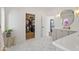 Bright bathroom showcasing marble floors, an open walk-in closet, and a vanity area with an elegant oval mirror at 6701 E San Miguel Ave, Paradise Valley, AZ 85253