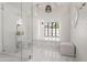 Bright bathroom with a glass-enclosed shower, unique lighting, marble floors, and a raised platform area with a window at 6701 E San Miguel Ave, Paradise Valley, AZ 85253