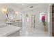 Bright bathroom featuring marble floors, dual vanities, arched windows, and a decorative wooden ladder for towels at 6701 E San Miguel Ave, Paradise Valley, AZ 85253