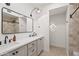 Bright bathroom featuring dual sinks, tile flooring, and a shower with light-colored tile at 6701 E San Miguel Ave, Paradise Valley, AZ 85253
