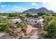 Stunning single-story home featuring a red tile roof, circular driveway, and mature landscaping with a mountain view at 6701 E San Miguel Ave, Paradise Valley, AZ 85253
