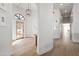 Foyer with a grand wooden front door, light wood floors, and elegant white walls at 6701 E San Miguel Ave, Paradise Valley, AZ 85253