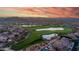 An aerial view captures a scenic golf course community against a vibrant sunset sky highlighting luxurious homes and amenities at 7130 E Saddleback St # 58, Mesa, AZ 85207