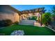 Lush backyard with artificial turf, desert landscaping, and outdoor kitchen at 7130 E Saddleback St # 58, Mesa, AZ 85207