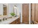 Bathroom with double vanity featuring granite countertop, wood cabinets, and matching mirrors at 7130 E Saddleback St # 58, Mesa, AZ 85207