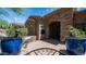 Charming front entrance with a bench, potted plants, brick archway, and wrought iron gate at 7130 E Saddleback St # 58, Mesa, AZ 85207