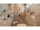 Tiled walk-in shower with stone bench and multiple shower heads at 7130 E Saddleback St # 58, Mesa, AZ 85207