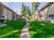 Lush courtyard with green grass, mature trees, and a inviting walkway at 7436 E Chaparral Rd # 124B, Scottsdale, AZ 85250