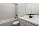 Clean, white bathroom with tub/shower combo and marble style tile at 7718 W Minton St, Laveen, AZ 85339