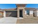 Charming single-story home featuring stone accents, a brown garage door, and a low-maintenance front yard at 7718 W Minton St, Laveen, AZ 85339