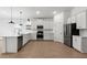 Open-concept kitchen with white cabinets, stainless steel appliances, and a stylish tile backsplash at 7718 W Minton St, Laveen, AZ 85339