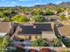 A home with solar panels on the roof, surrounded by flowering plants, mountains in the distance at 9127 E Siesta Ln, Scottsdale, AZ 85255