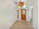 Bright foyer with a decorative glass front door, tile flooring, and high ceilings at 9127 E Siesta Ln, Scottsdale, AZ 85255