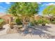 Attractive single-story home with desert landscaping featuring mature trees, cacti, and rock accents at 9127 E Siesta Ln, Scottsdale, AZ 85255