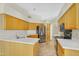 Spacious kitchen with light wood cabinetry, stainless steel appliances, and solid surface countertops at 9127 E Siesta Ln, Scottsdale, AZ 85255