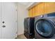 Well-equipped laundry room with modern washer and dryer, storage cabinets above at 9127 E Siesta Ln, Scottsdale, AZ 85255