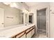 Well-lit bathroom featuring an extended vanity, a large mirror, and a step-in shower at 9511 W Carol Ave, Peoria, AZ 85345