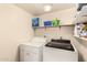 This laundry room includes a washer, dryer and storage shelves at 9511 W Carol Ave, Peoria, AZ 85345