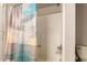 Close up of a tile shower with neutral ocean-themed shower curtain at 9511 W Carol Ave, Peoria, AZ 85345