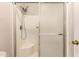 Step-in shower stall with glass doors, a built-in seat, and updated showerhead at 9511 W Carol Ave, Peoria, AZ 85345