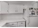 Bright kitchen featuring white cabinets, appliances, and countertops with marble-look finish at 10101 N Arabian Trl # 2018, Scottsdale, AZ 85258