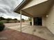 Covered patio area featuring concrete and brick surfaces, leading to a spacious, low-maintenance gravel backyard at 11022 S Iroquois Dr, Phoenix, AZ 85044