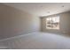 A spacious bedroom with plush carpeting and a bright window showcasing neighborhood views at 11300 N Casa Dega Dr # 1081, Surprise, AZ 85388