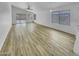 Bright living room featuring wood-look floors, sliding glass doors, and a ceiling fan at 1211 S Pueblo Ct, Gilbert, AZ 85233