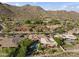 Expansive aerial view of a luxury home, pool, and lush landscaping nestled in a desert mountain community at 13249 E Summit Dr, Scottsdale, AZ 85259