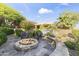 Backyard with a fire pit, built in water feature, mature landscaping, and seating area at 13249 E Summit Dr, Scottsdale, AZ 85259