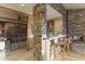 Basement wet bar with stone accents, bar seating, and a fireplace, ideal for entertaining guests at 13249 E Summit Dr, Scottsdale, AZ 85259