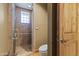 Bathroom featuring walk-in shower with glass door, tiled walls, and a wooden door at 13249 E Summit Dr, Scottsdale, AZ 85259