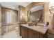 Luxurious bathroom with stone walls, a granite countertop, a vintage mirror, and custom lighting at 13249 E Summit Dr, Scottsdale, AZ 85259