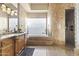 Luxurious bathroom with a soaking tub, glass block window, and dual sink vanity, spa-like retreat at 13249 E Summit Dr, Scottsdale, AZ 85259