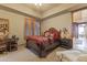 Cozy bedroom featuring a queen bed, neutral decor, plantation shutters, and ensuite bath at 13249 E Summit Dr, Scottsdale, AZ 85259