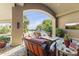 Covered patio with outdoor seating, a fireplace, and views of the lush backyard landscape at 13249 E Summit Dr, Scottsdale, AZ 85259