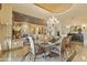 Open-concept dining room with a stone fireplace and elegant chandelier adjacent to living room and kitchen at 13249 E Summit Dr, Scottsdale, AZ 85259
