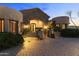 Nighttime view of home exterior featuring stone accents, manicured landscaping, and an arched entryway at 13249 E Summit Dr, Scottsdale, AZ 85259