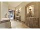 Elegant foyer with travertine floors, designer lighting, and a custom niche for decorative display at 13249 E Summit Dr, Scottsdale, AZ 85259