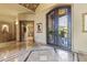 Grand foyer with decorative marble flooring and an ornate iron door, offering a glimpse of the outdoor landscape at 13249 E Summit Dr, Scottsdale, AZ 85259