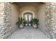 Elegant stone entryway and double wrought iron doors, accented by potted plants, creates an inviting front entrance at 13249 E Summit Dr, Scottsdale, AZ 85259