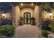 Grand front entrance with stone archway, ornate iron gates, and lush landscaping adding curb appeal at 13249 E Summit Dr, Scottsdale, AZ 85259